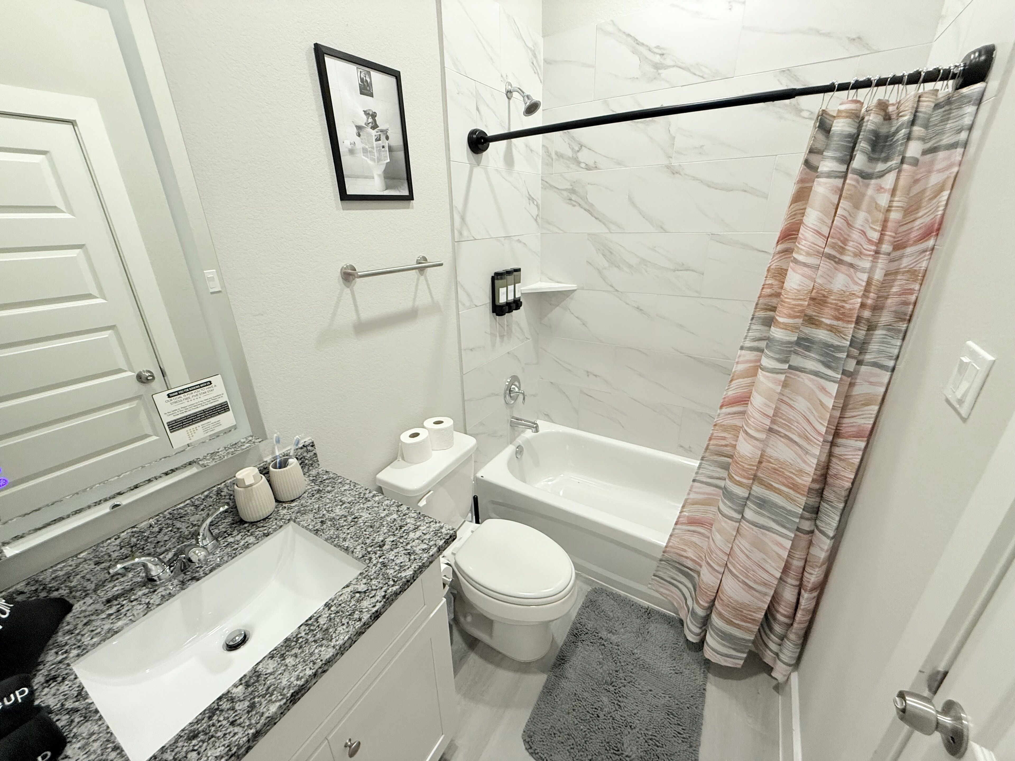 A bathroom with a sink, toilet, bathtub, and shower curtain.