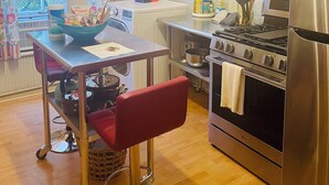 A kitchen with a stainless steel refrigerator, an LG oven, a gas stove, and a washing machine. - Charming 2-bedroom apartment in peaceful Warren with AC (Warren)