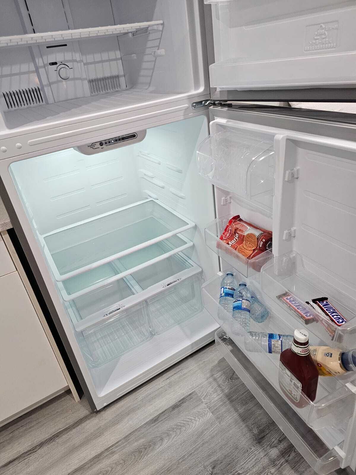 Una cocina moderna con refrigerador integrado, microondas y pileta.
