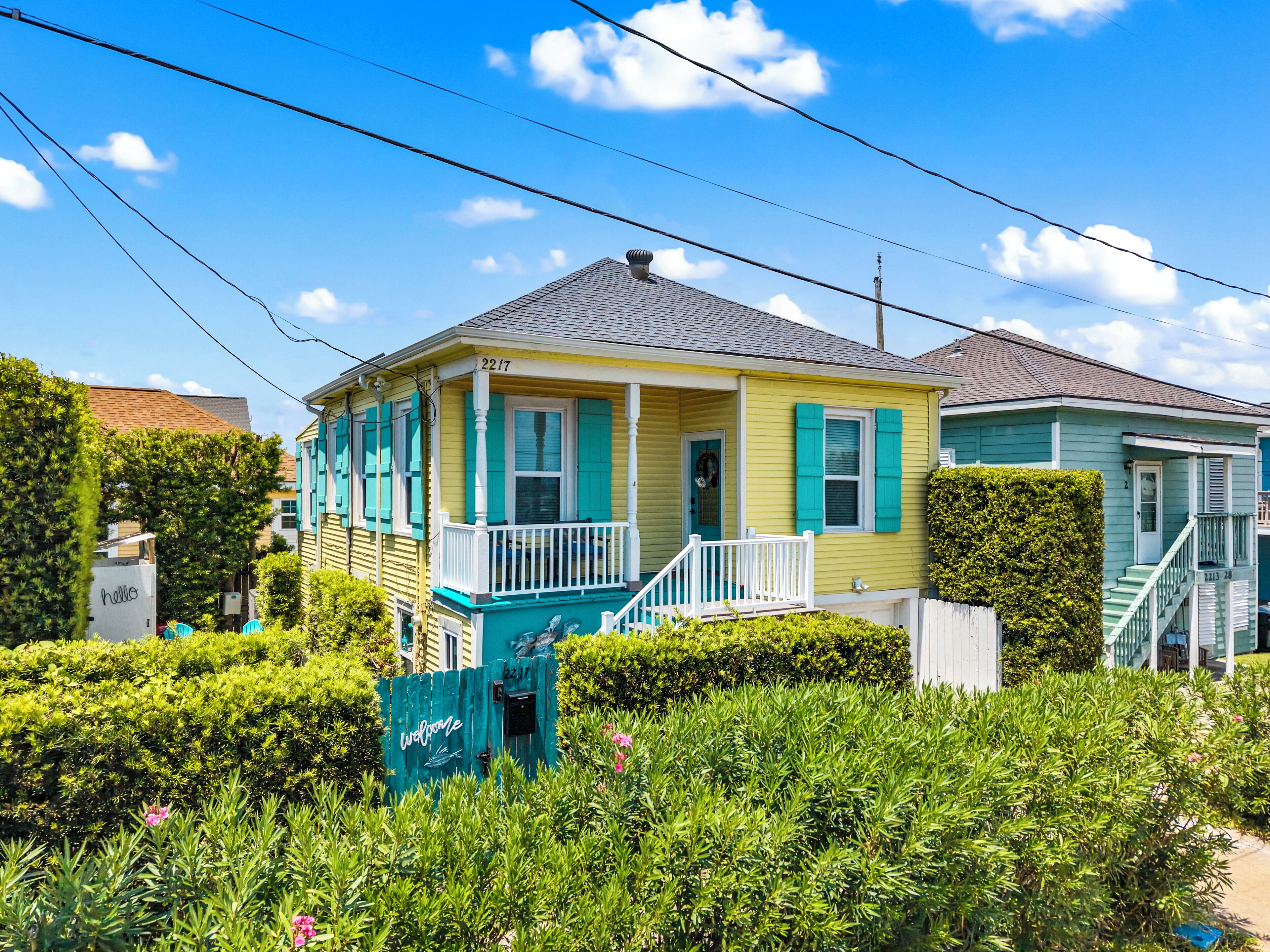 A two-story house with a porch, a mailbox, and a well-maintained garden.