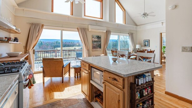 A spacious kitchen with a large island, wooden cabinets, and a view of the outdoors.