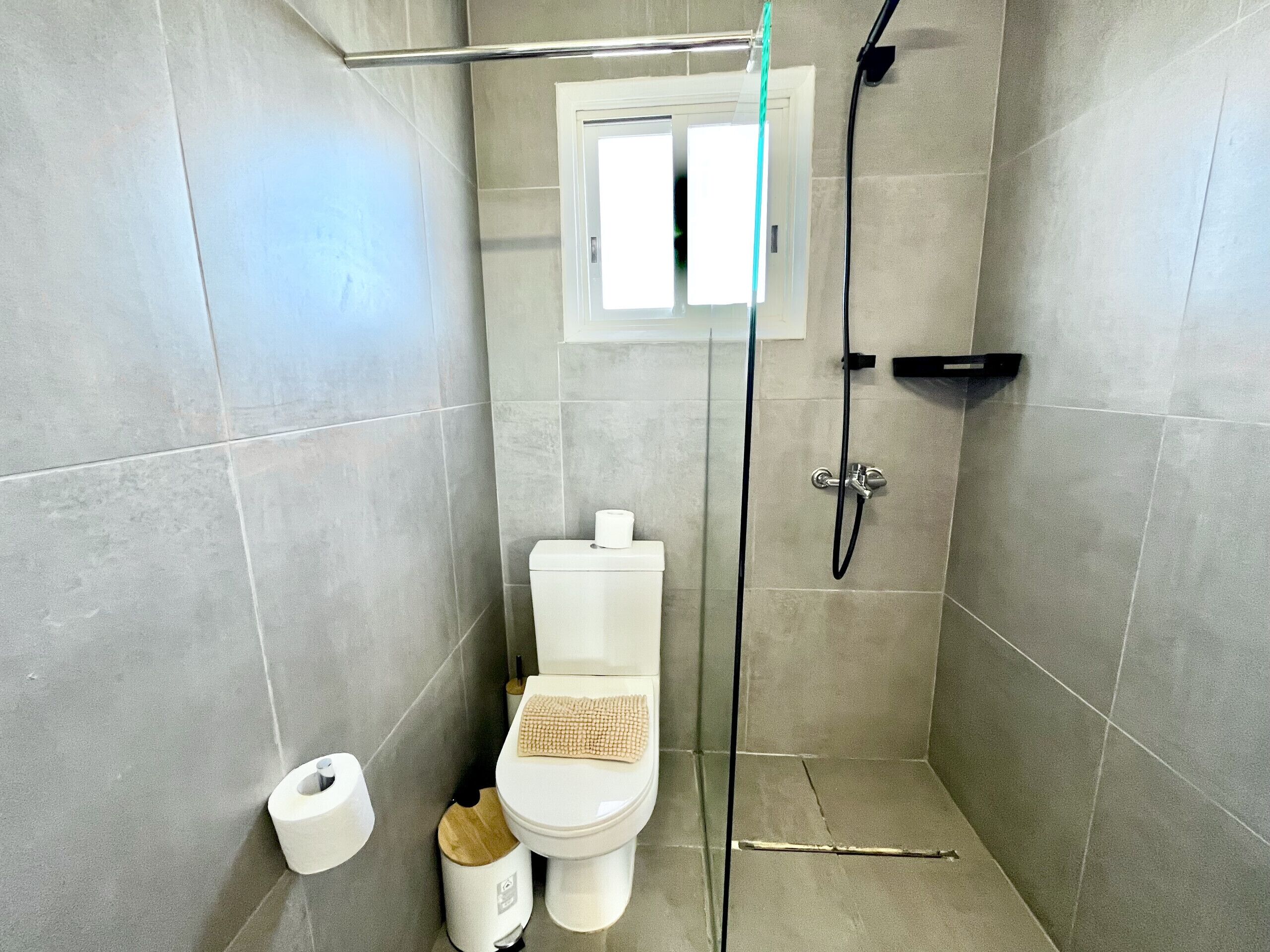 Un baño pequeño y moderno con inodoro, bidé y zona de ducha.