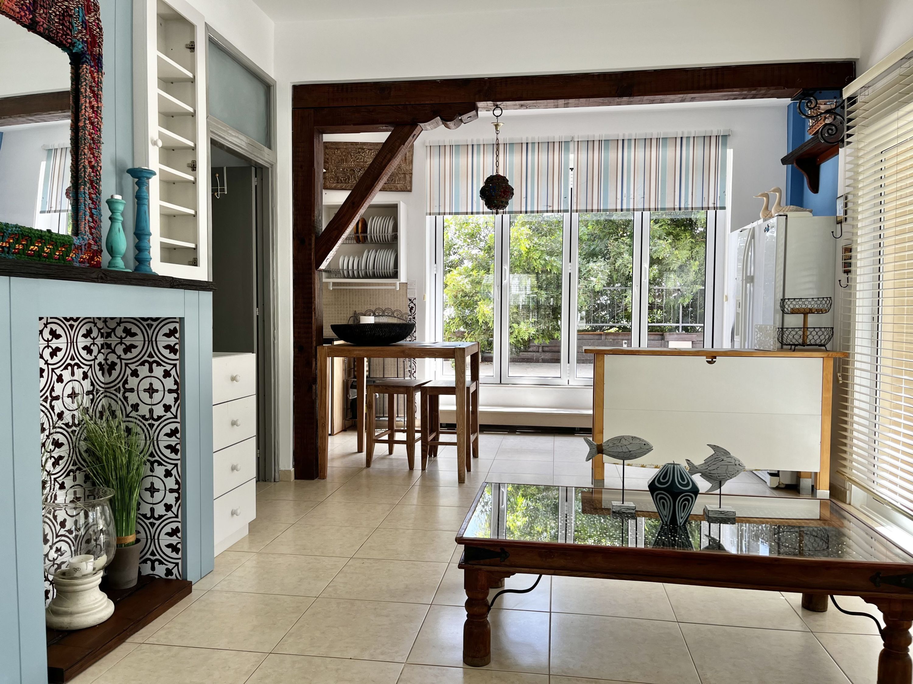 A spacious kitchen with a dining area, featuring a large window, a wooden table, and a decorative fish sculpture.