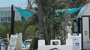 Schild an einer Strandstraße für Wassersport, das private Sonnenuntergangstouren für 45 Dollar bewirbt.