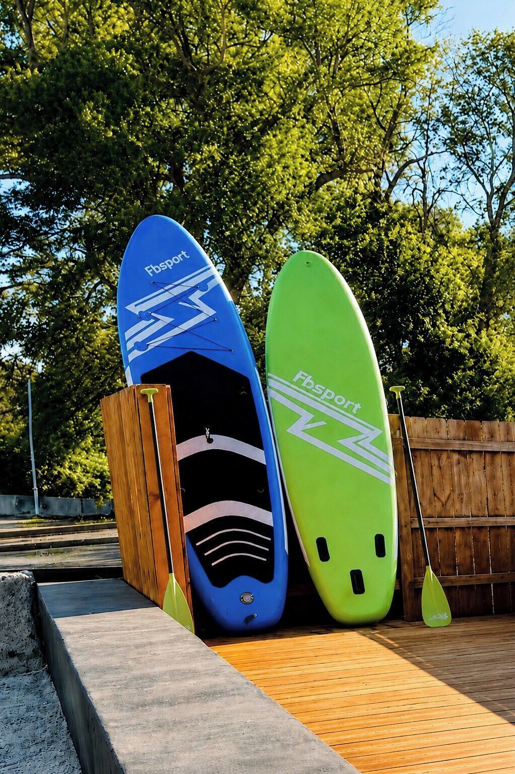 Two surfboards leaning against a wooden fence.