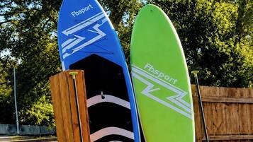 Two surfboards leaning against a wooden fence.