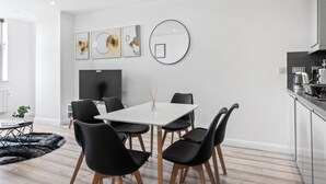 Una cocina moderna con comedor, paredes blancas y decoración contemporánea.