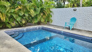 A rectangular swimming pool with blue mosaic tiles, surrounded by a concrete deck and a white textured wall. - Feel-good oasis Playa Sámara, Ocean view, Private pool, King bed, Dishwasher (Sámara)