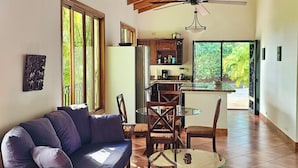 A spacious living area with a wooden ceiling, a glass dining table, and a sofa. - Feel-good oasis Playa Sámara, Ocean view, Private pool, King bed, Dishwasher (Sámara)