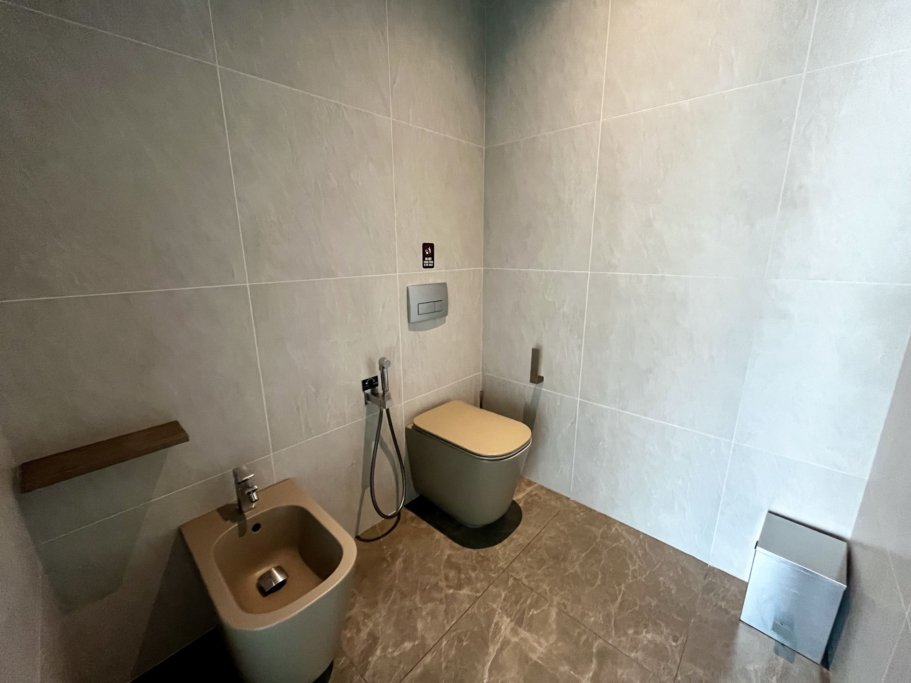 Un baño moderno con bidé, inodoro y secamanos.