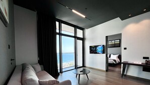 A modern hotel room with a large window, a sofa, a small table, and a bed. - 128 LIM - 2001 Stay Only Tower Suite (Limassol)
