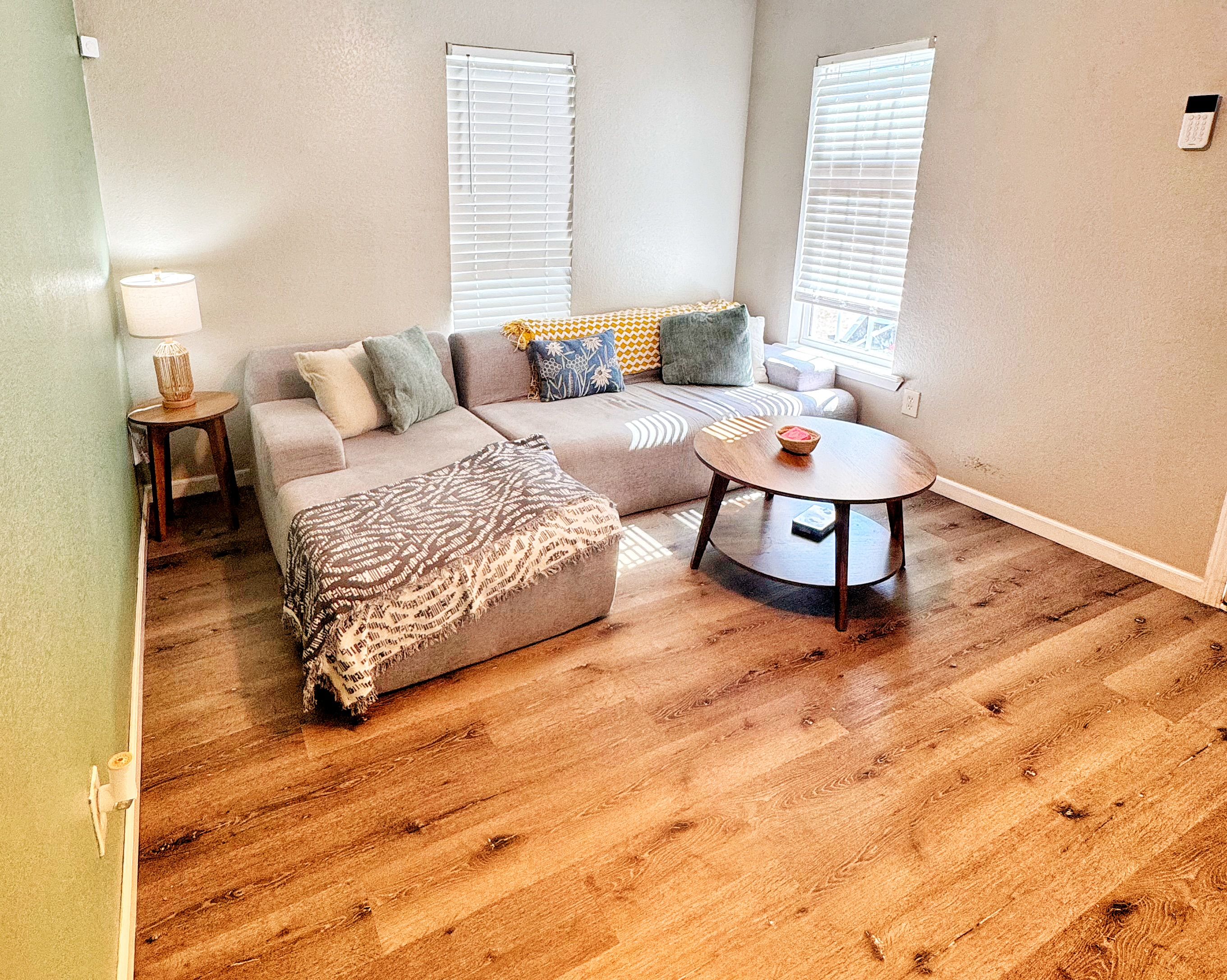 A living room with a sofa, a coffee table, and a lamp.