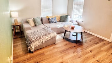 A living room with a sofa, a coffee table, and a lamp.