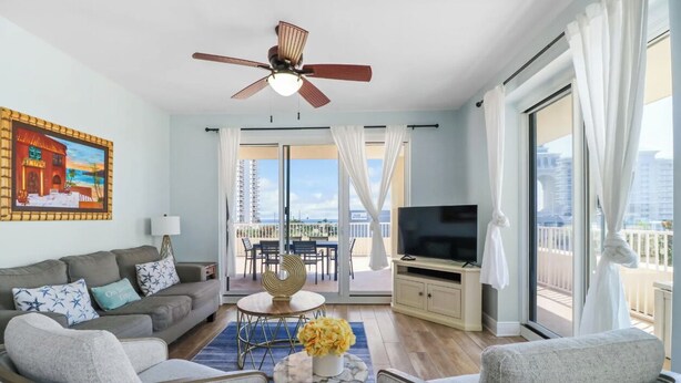 A living room with a sofa, chairs, a TV, a ceiling fan, and a balcony with a view. - 🦩Sunset Chaser at Ariel Dunes🦩 (Destin)