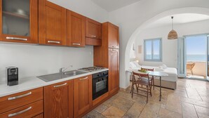 A modern kitchen with wooden cabinets, a built-in oven, and a sink. - Akti Giannaki (Tinos)