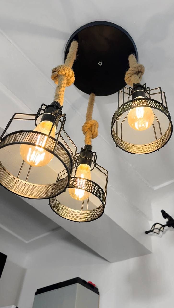 A ceiling with three pendant lights featuring exposed bulbs and a rope design.