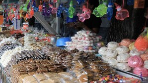 Un'ampia selezione di prodotti confezionati, tra cui caramelle e snack, esposti in un mercato.
