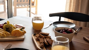 Une table de petit-déjeuner avec une variété d’aliments, notamment des fruits, du pain et un verre de jus d’orange.