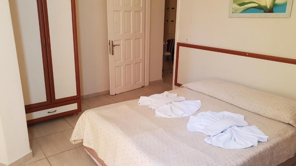 A bedroom with a bed, a wardrobe, and a door.
