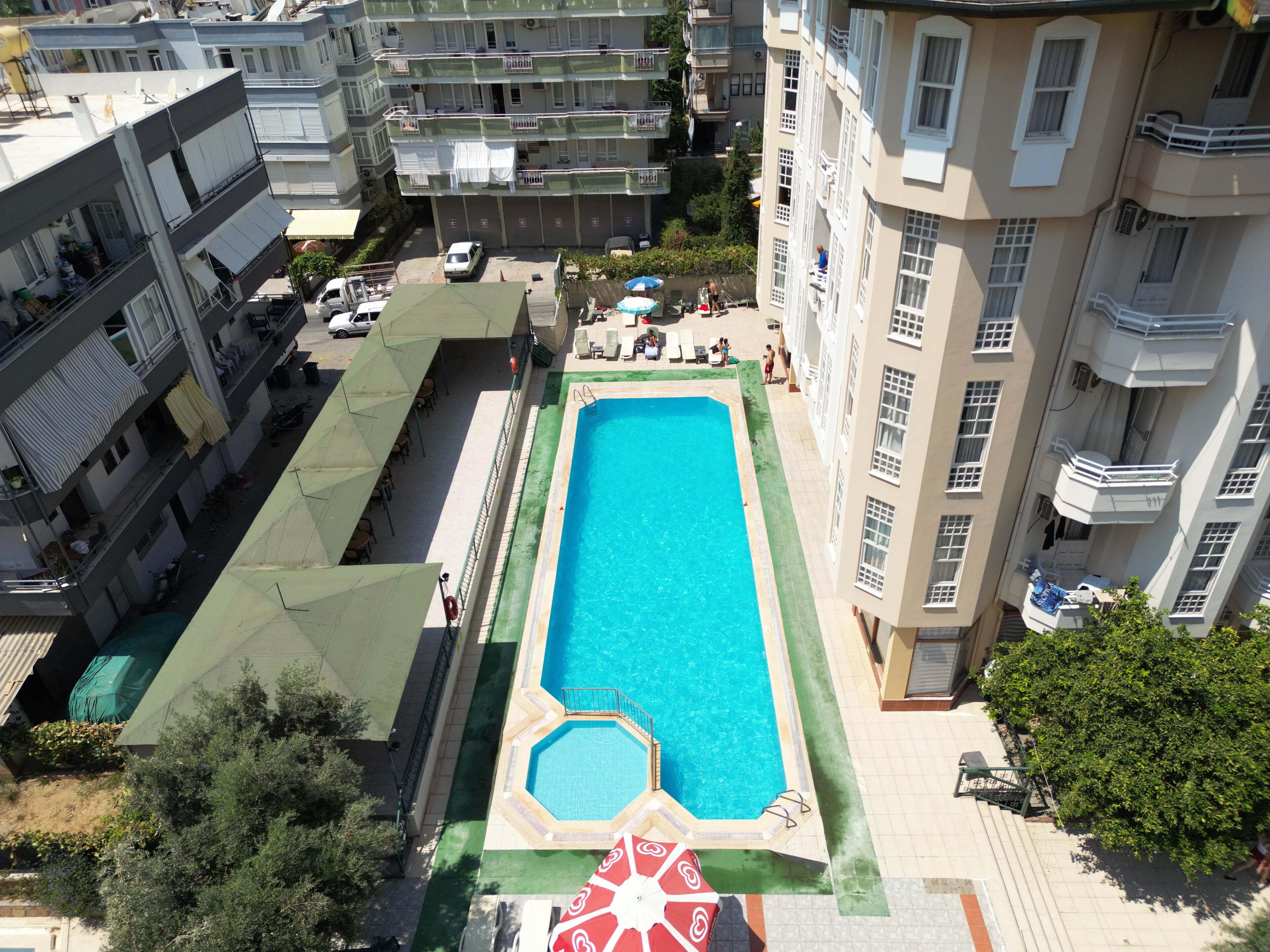Una piscina en la azotea rodeada de edificios residenciales de varios pisos.