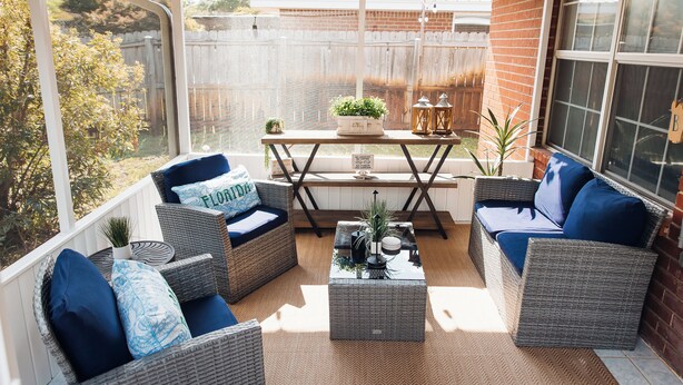 A covered patio with wicker furniture, a coffee table, and a view of a backyard. - Golden Hour Getaway-2 Minutes to Beach, Pool + Arcade, Sleeps 10, (Destin)