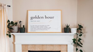 A living room with a fireplace, a framed quote on the mantel, and potted plants. - Golden Hour Getaway-2 Minutes to Beach, Pool + Arcade, Sleeps 10, (Destin)