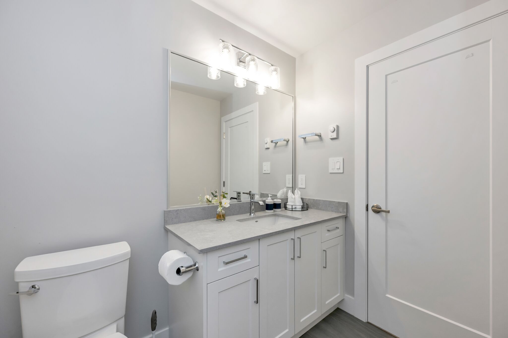 Ein modernes Badezimmer mit Toilette, Waschbecken und Spiegel.