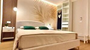 A modern bedroom with a large bed, a nightstand, a wardrobe, and a wall-mounted shelf. - Villa Sable D'or-Avola (Gallina Beach) just 350 meters from the sea(Sicily) (Gallina)