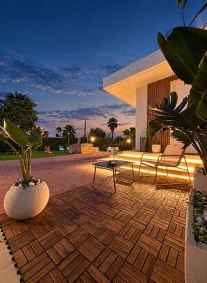 A patio area with a wooden floor, a table, and two chairs.