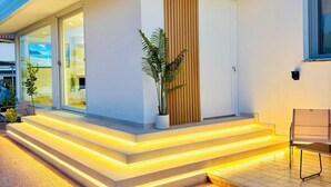 A modern house with a flat roof, a large sliding glass door, and a wooden panel wall. - Villa Sable D'or-Avola (Gallina Beach) just 350 meters from the sea(Sicily) (Gallina)