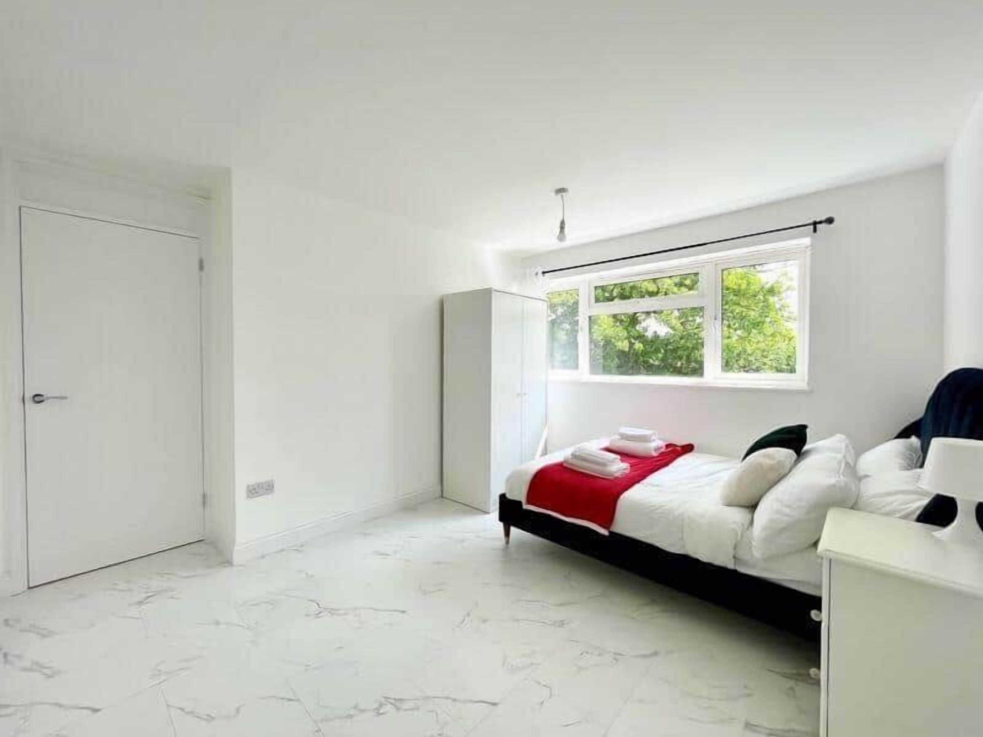 Un dormitorio moderno con una cama, una ventana y una puerta.