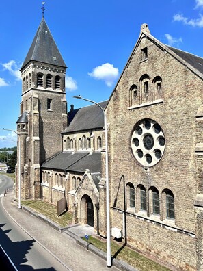 A historic church with a prominent tower and a large circular window. - Cosy haven Aalst - terrace a green haven (Aalst)