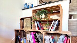 Un coin d’une pièce avec une bibliothèque en bois remplie de livres et une petite plante en pot.