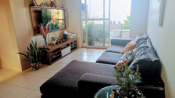 A living room with a sofa set, a TV, and a bookshelf.