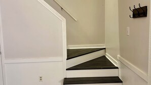 A staircase with white walls and dark wooden steps. - Cozy retreat in Athens - convenient location, walk to Five Points, close to UGA. (Athens)