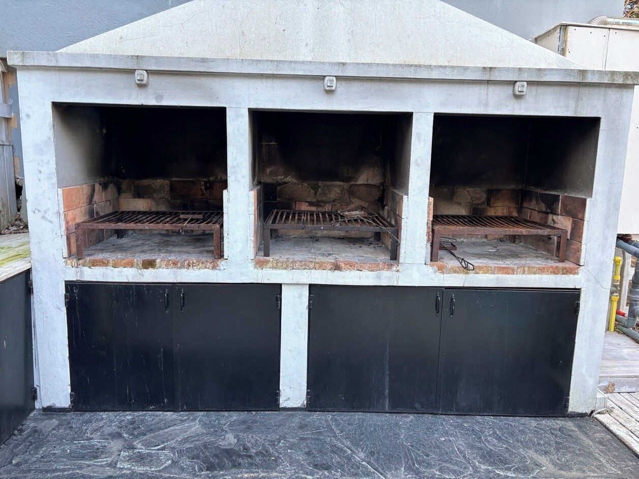 A three-section outdoor grill with a black lower section and a white upper section.