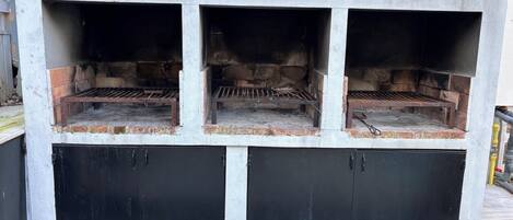 A three-section outdoor grill with a black lower section and a white upper section.