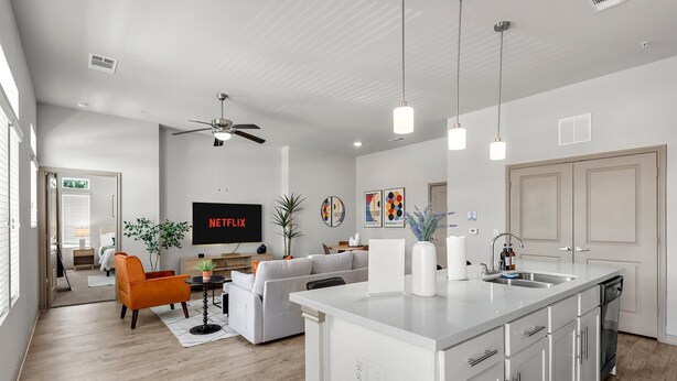 A modern living room with a sofa, a coffee table, and a TV displaying Netflix. - Modern 2-bedroom close to Airport & Downtown - Pool, Gym & Balcony (Austin)