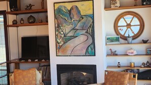 Ein gemütliches Wohnzimmer mit Kamin, Holzmöbeln und Dekorationselementen.