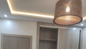 A bedroom with a bed, a wardrobe, and a hanging light fixture. - Chambre calme (Amizmiz)