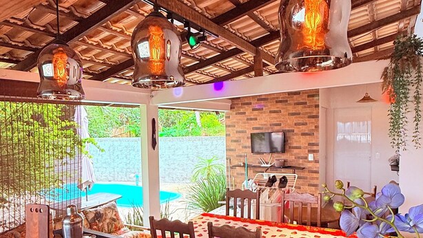 Un restaurant doté d’un bar en bois, de luminaires suspendus et d’un mur en briques sur lequel est accroché un téléviseur.