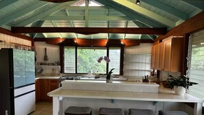 Una cocina con una isla grande, armarios de madera y vistas al exterior.