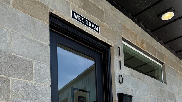 A building entrance with a black door, a 'WEE DRAM' sign, and the number '110' on the wall. - 18 Miles to Clemson & 13 Miles to Greenville 2 Bd 2.5 Bath Bourbon Lovers Dream (Easley)