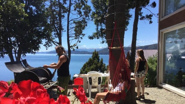 Un patio con una parrilla, asientos exteriores y vistas al mar.