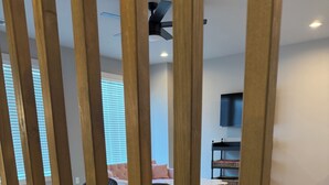 Een moderne woonkamer met een houten vloer, een bank, een salontafel en een televisie.