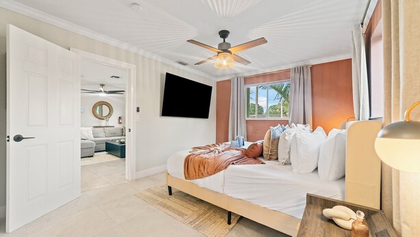 A bedroom with a bed, a ceiling fan, a TV, and a window with curtains. - Sunny-Haven 3 Bedroom PoolVilla With GameRoom near the Beach & Shopping Centers (Plantation)