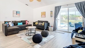 A modern living room with two sofas, a coffee table, and a ceiling fan. - Smiling Disney Oasis heated pool home in Kissimmee with Game room. (Kissimmee)