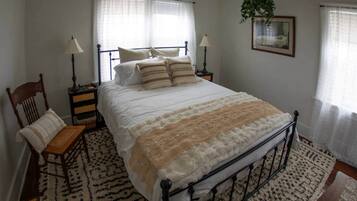 This main floor bedroom includes a comfortable bed, dresser, tv, nightstands with charging stations and closet.