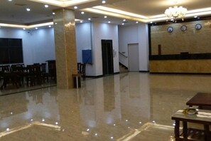 A spacious room with a polished floor, a chandelier, and a clock on the wall. - Fenglinge Hotel (Zhangjiajie)