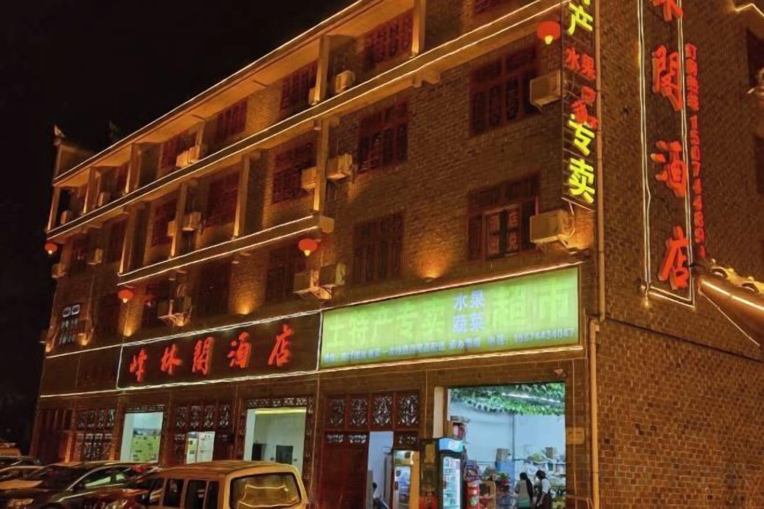 A multi-story building with illuminated signage and a storefront.